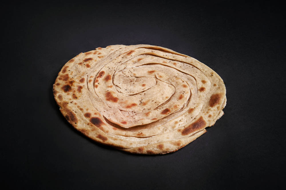 46.  Lachaa Parantha /55,-  Ugjæret grov brød fylt med smør og bakt i tandoor. Butter layered whole-wheat flour bread baked in tandoor. *Lactose, Gluten